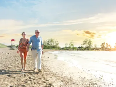 Couple walking along Goderich beach during sunset